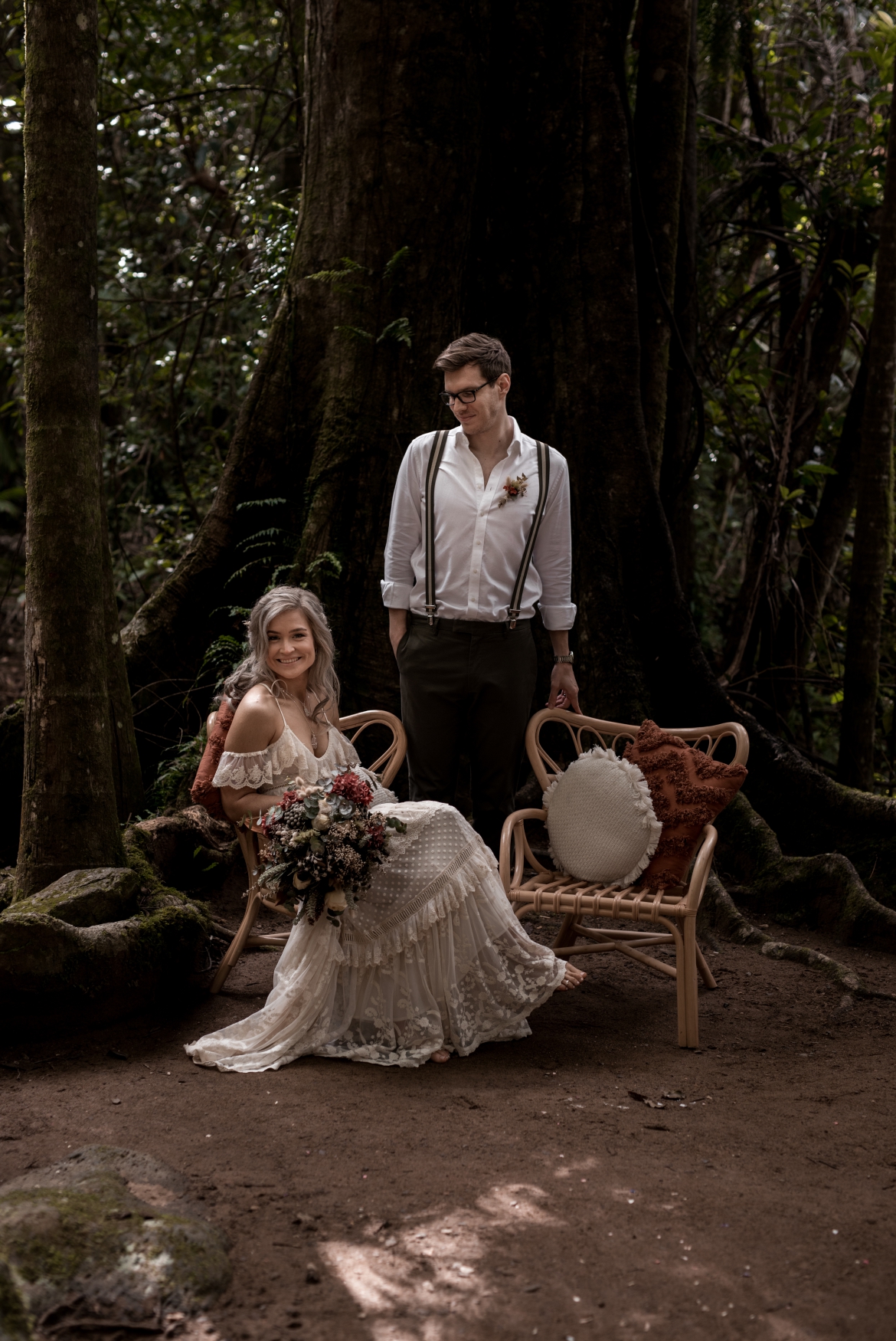 Sitting on a rattan chair beneath the fig tree at Crystal creek rainforest retreat elopement with bohoelope