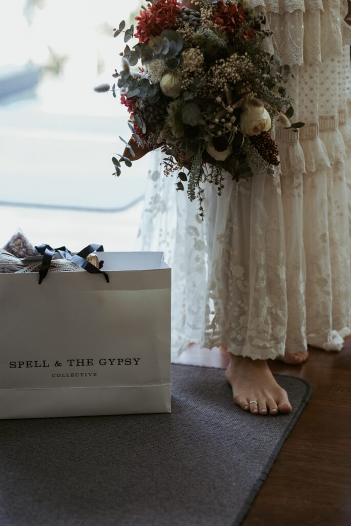 Detail photo of the bride and her spell and the gypsy dress bag while holding her wedding bouquet at crystal creek rainforest retreat (CCRR)