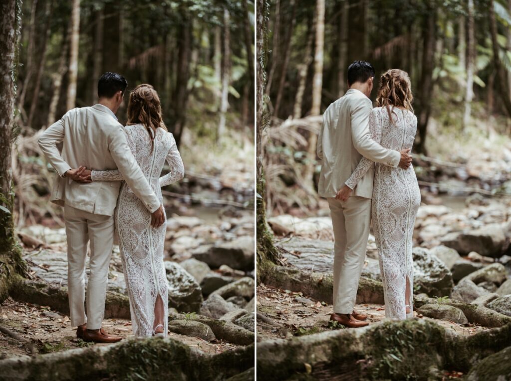 The couple sharing a moment after the ceremony look at the creek while holding each other at crystal creek rainforest retreat. CCRR