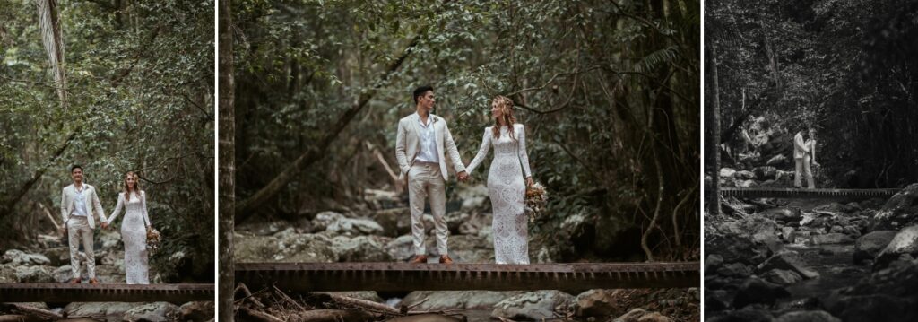 The couple standing on a foot bridge holding hands in the rainforest at crystal creek rainforest retreat. CCRR