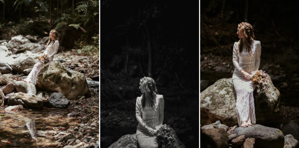 Portraits if the bride sitting on huge boulders in spot lit by the sun in the creek at crystal creek rainforest retreat. CCRR