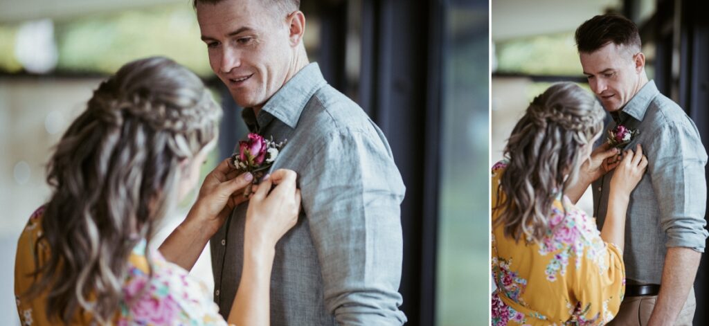 The bride attaching the grooms buttonhole to her future husbands linen shirt In the springbrook mountain view lodge at crystal creek rainforest retreat, nsw . CCRR